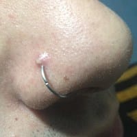 Volita roja arriba del pircing de la nariz.